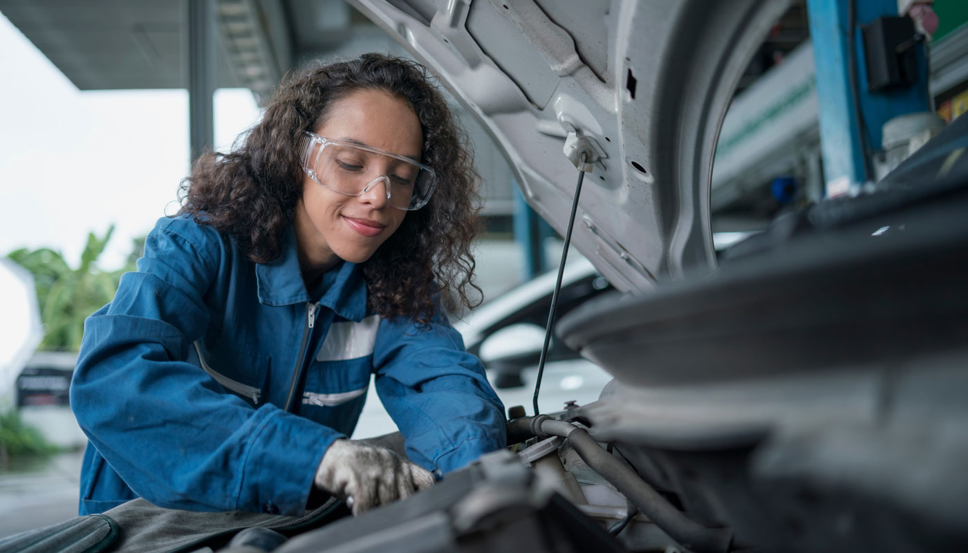 female auto mechanic checking car diagnostics at workshop. car service, repair, maintenance.