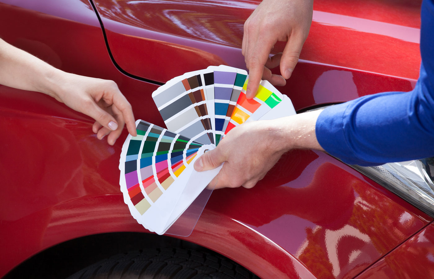 Color wheel shown in front of a red car