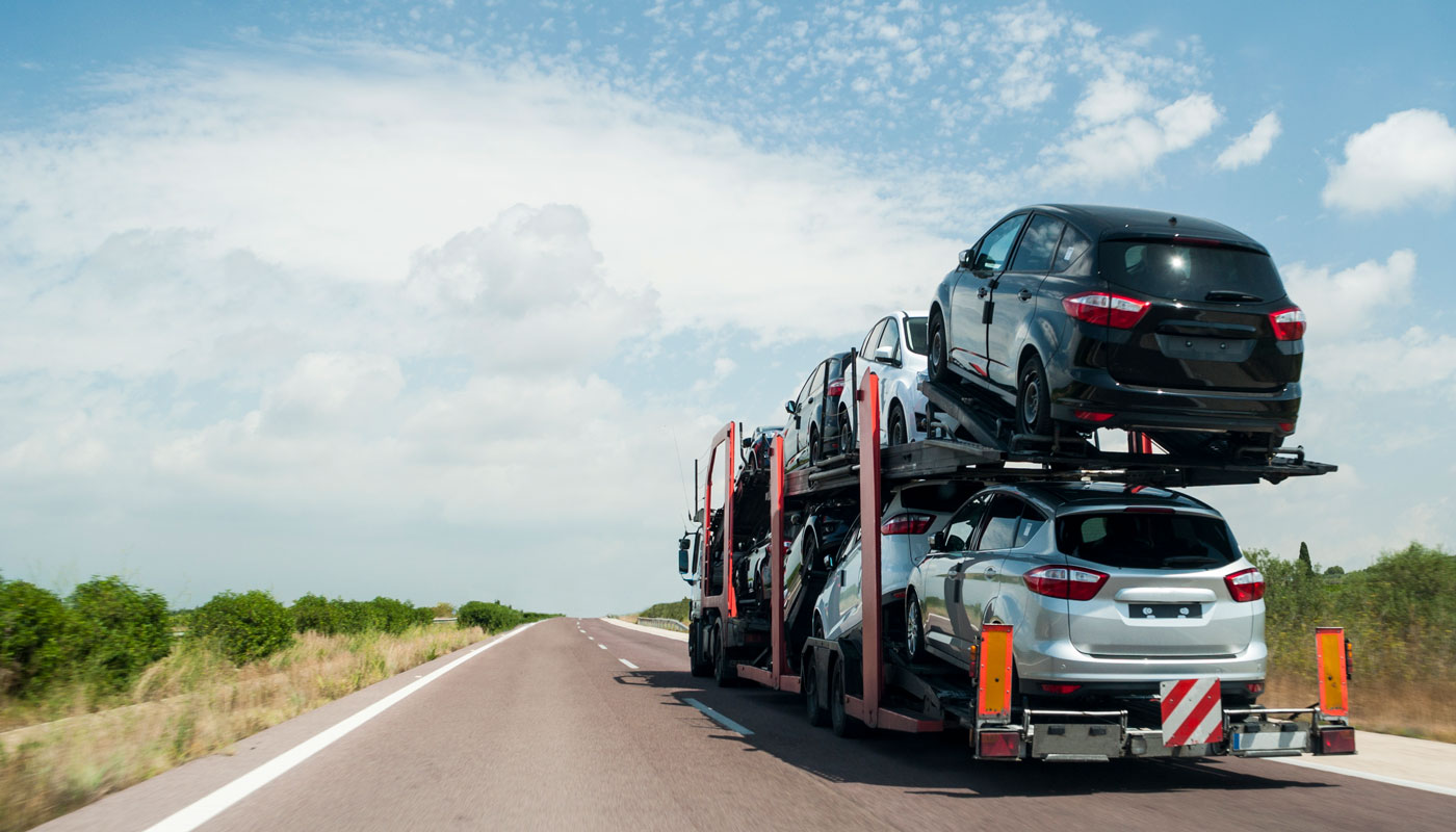 semi hauling cars on a highway