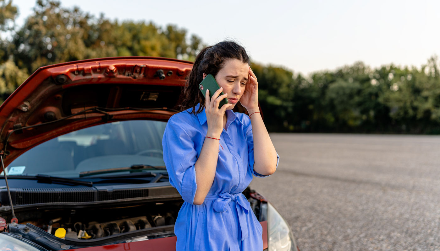 ung woman uses phone to call for roadside aid