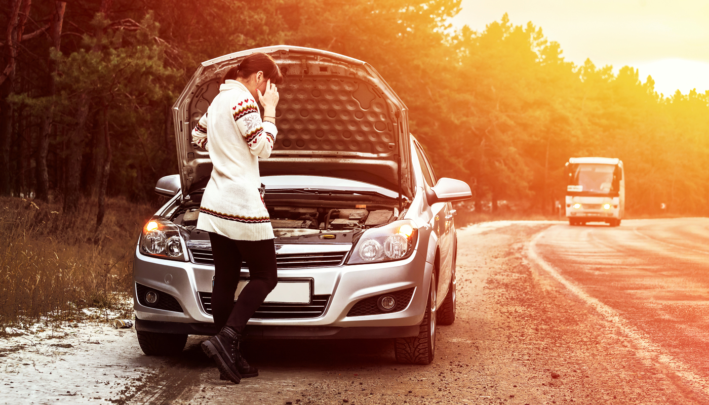 Woman on side of the road with her car hood up and talking on her mobile phone.