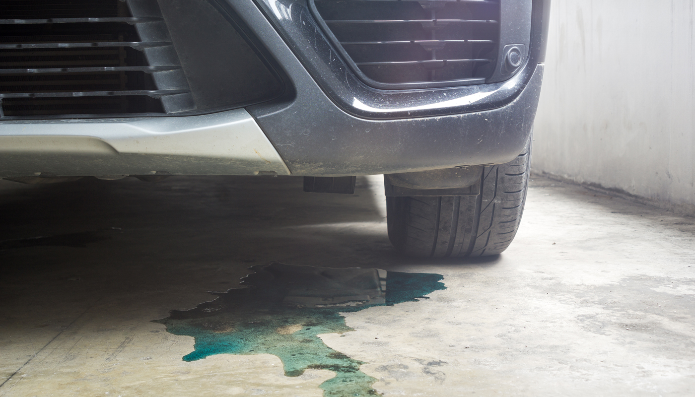 Car parked with water coolant liquid leak out from the engine down on the floor background