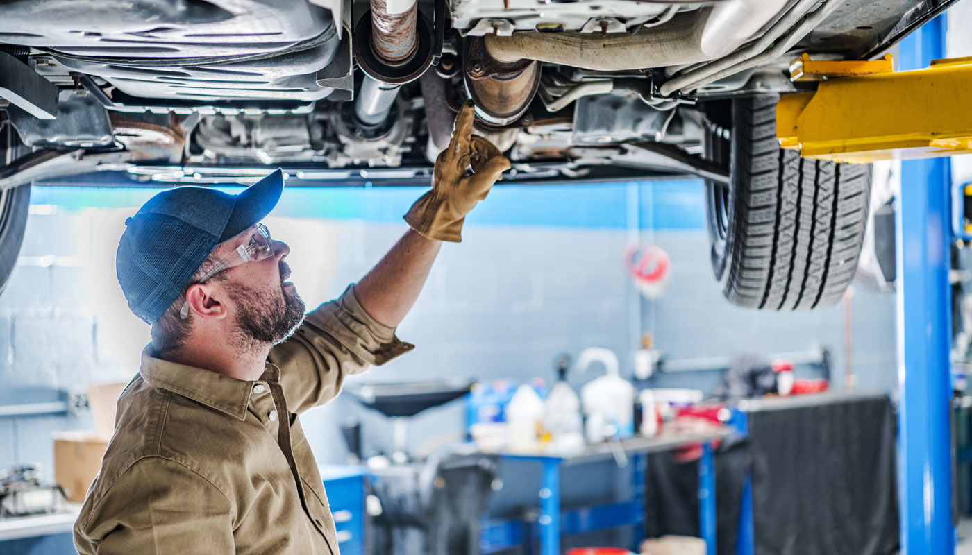 Professional Mechanic Performing Car Undercarriage Inspection