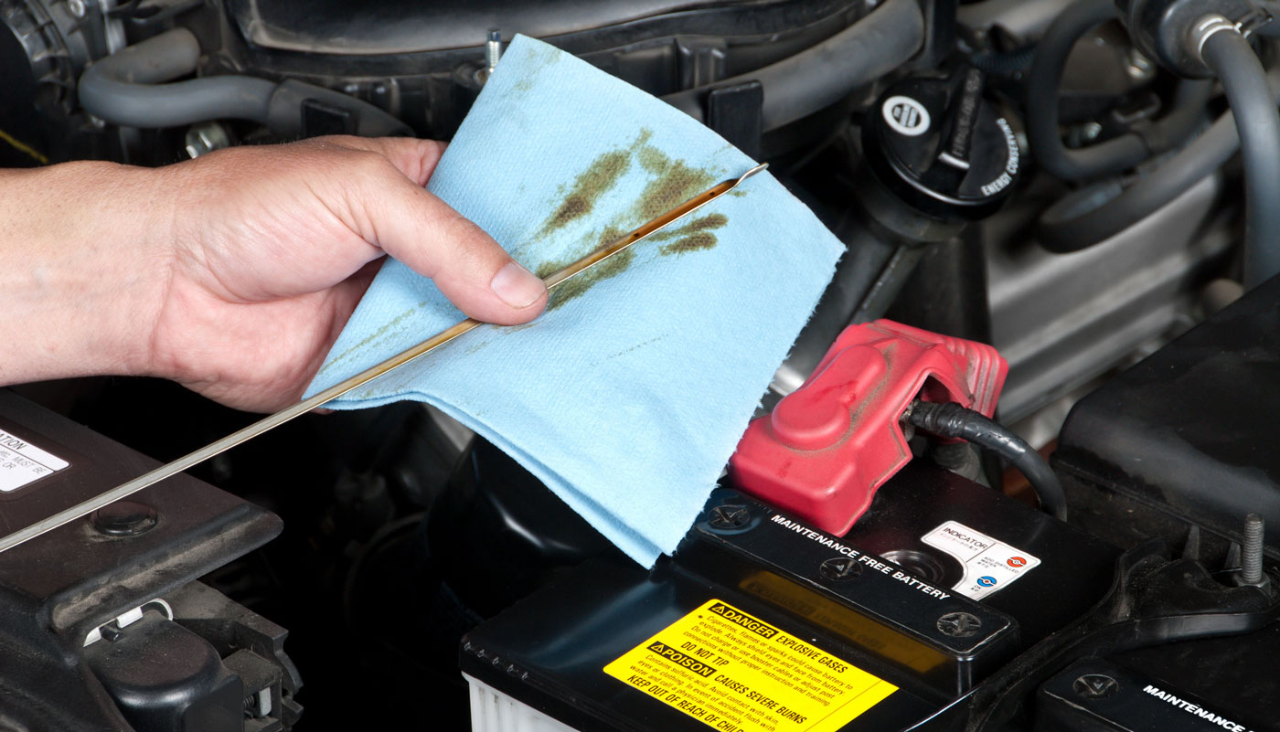 Checking the dipstick of a car's motor oil