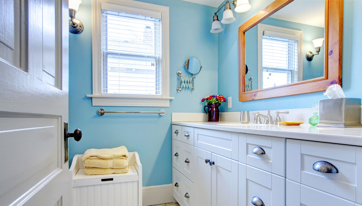 Blue and white bathroom with lots of storage space.