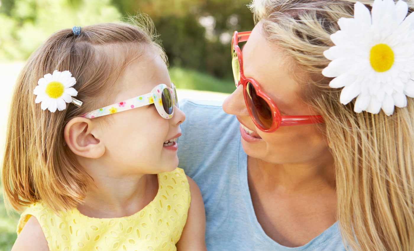 Mother And Daughter Playing In Garden with sunglasses on