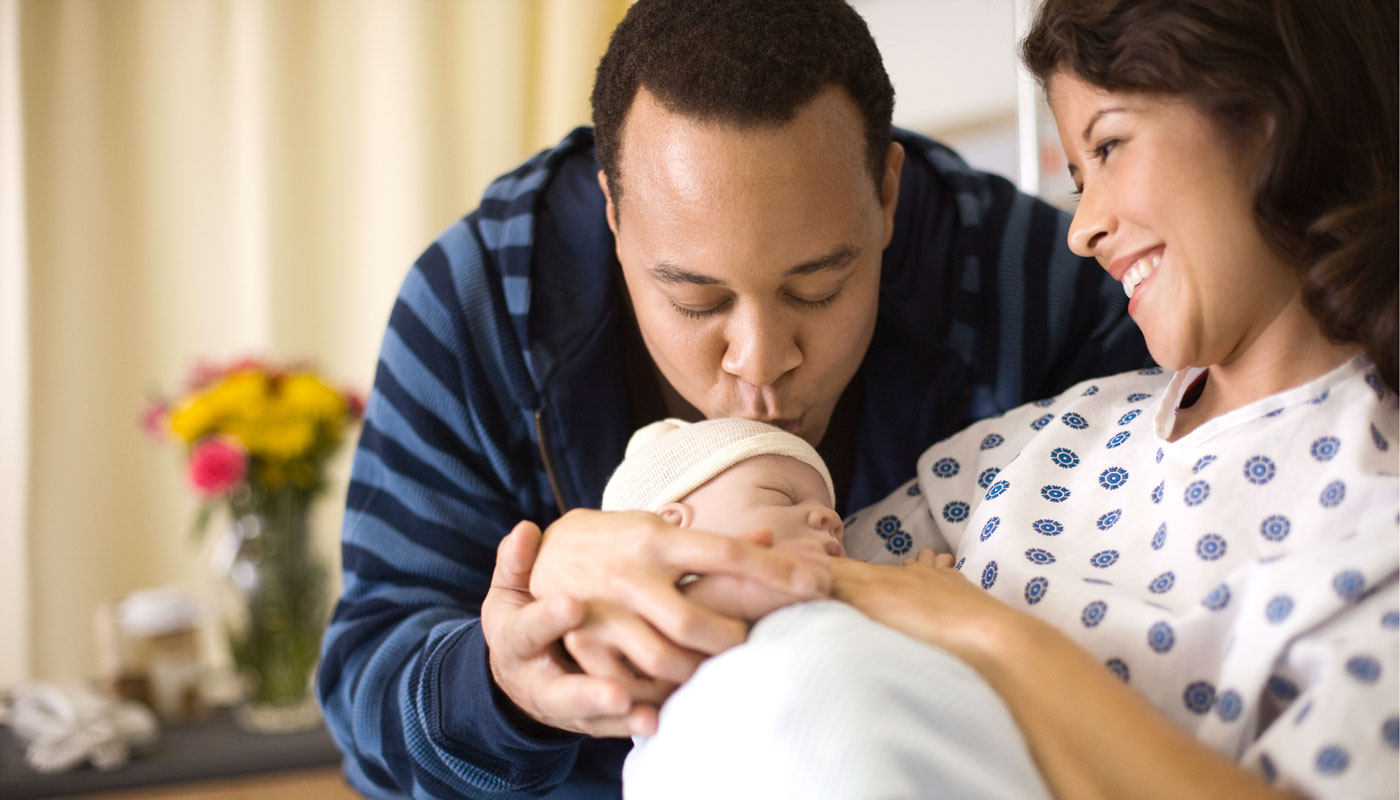 Man and woman with newborn baby in hospital setting