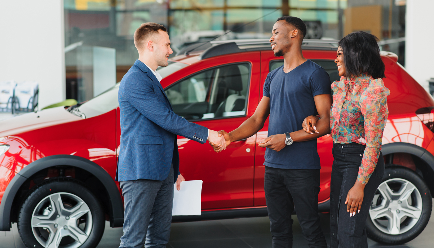 young couple buying new car at dealership