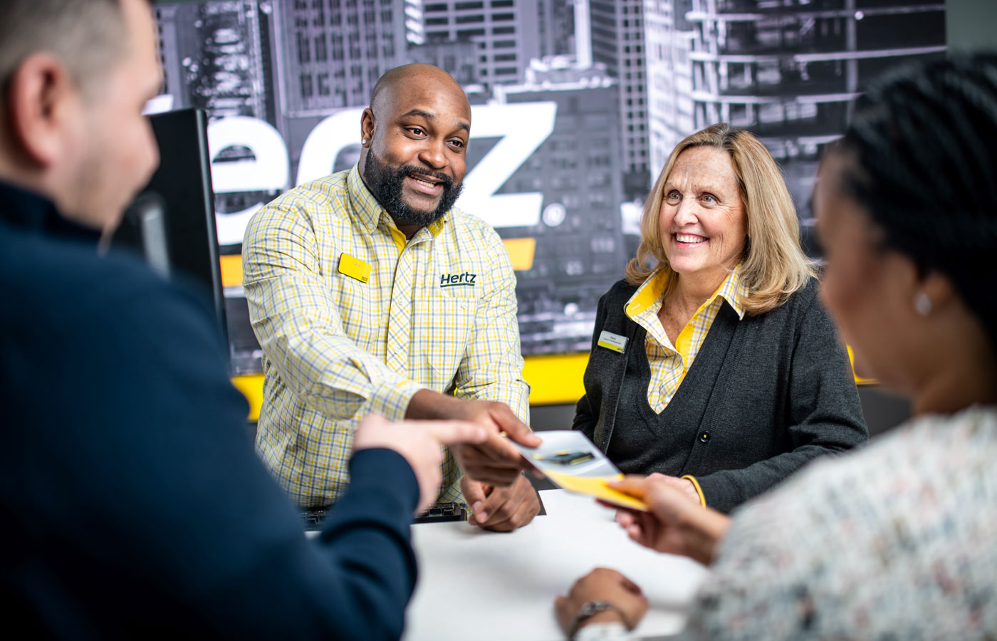 Hertz counter working with a couple to get their rental car