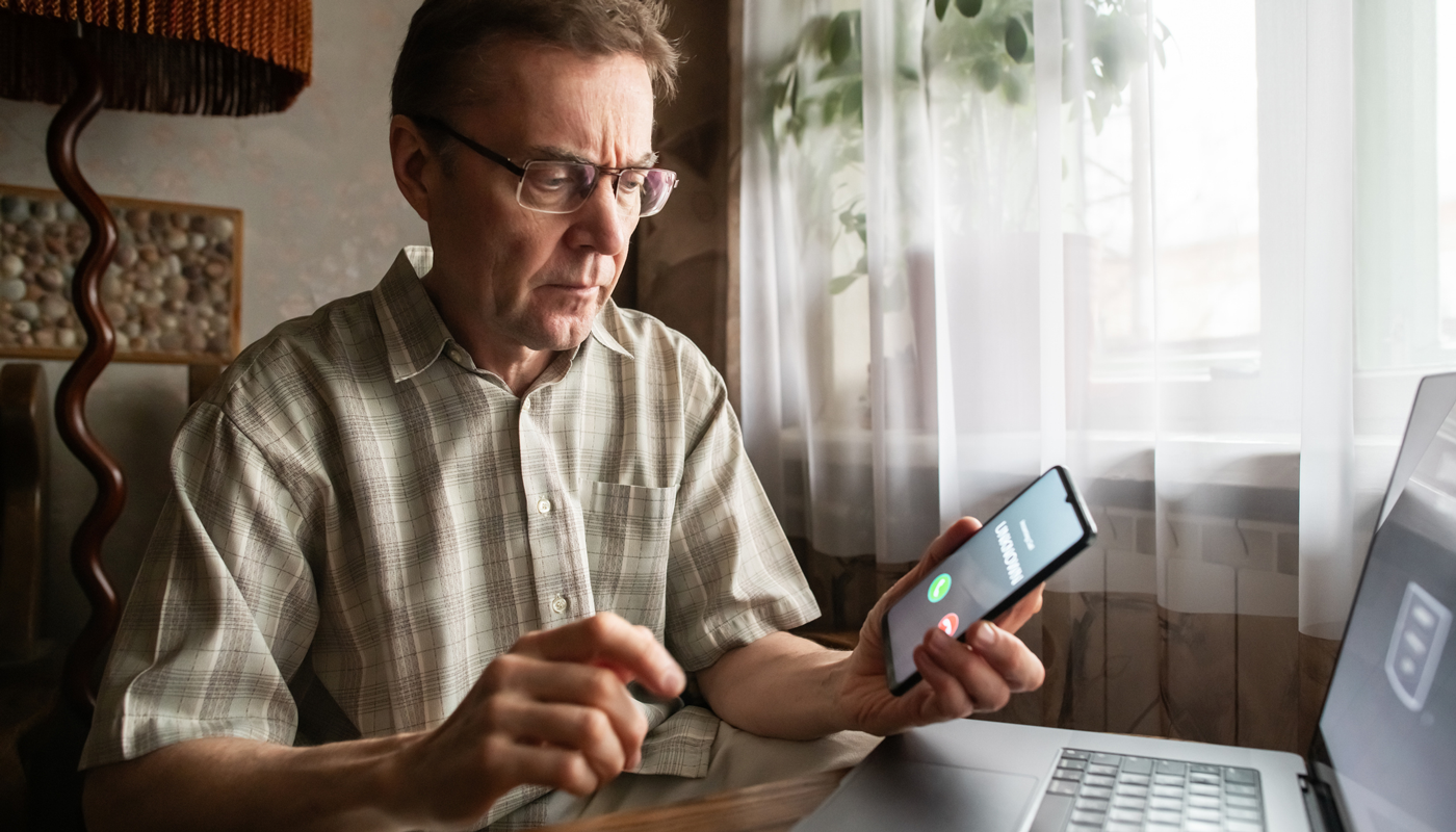 Senior man receiving a call from unknown number