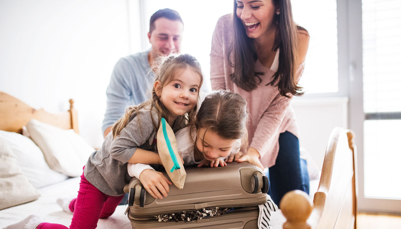 Young family with two children packing for cruise.