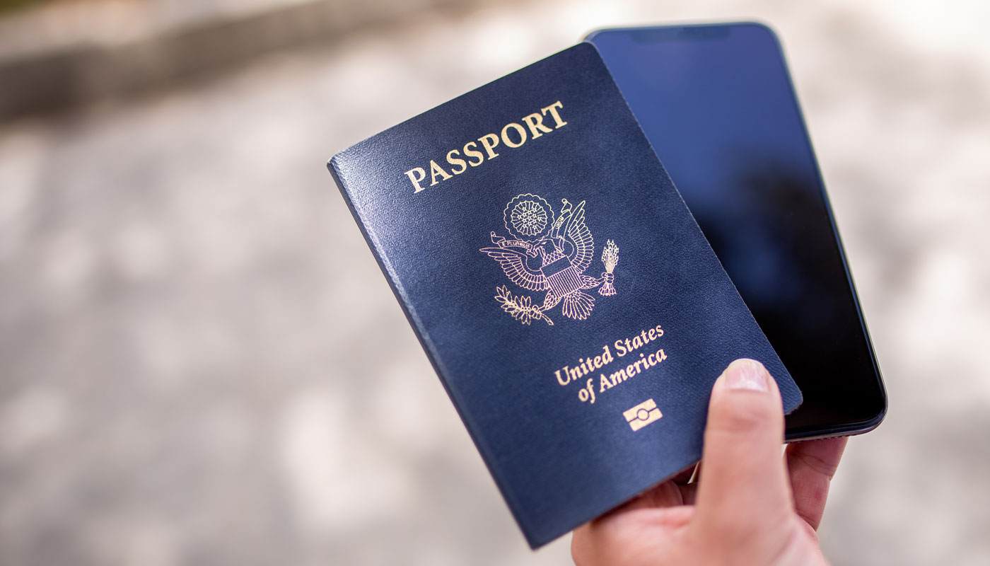 Holding a blue American passport and a black smartphone