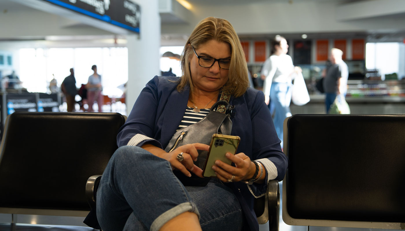 Marti Gonzalez checking her phone while at the airport