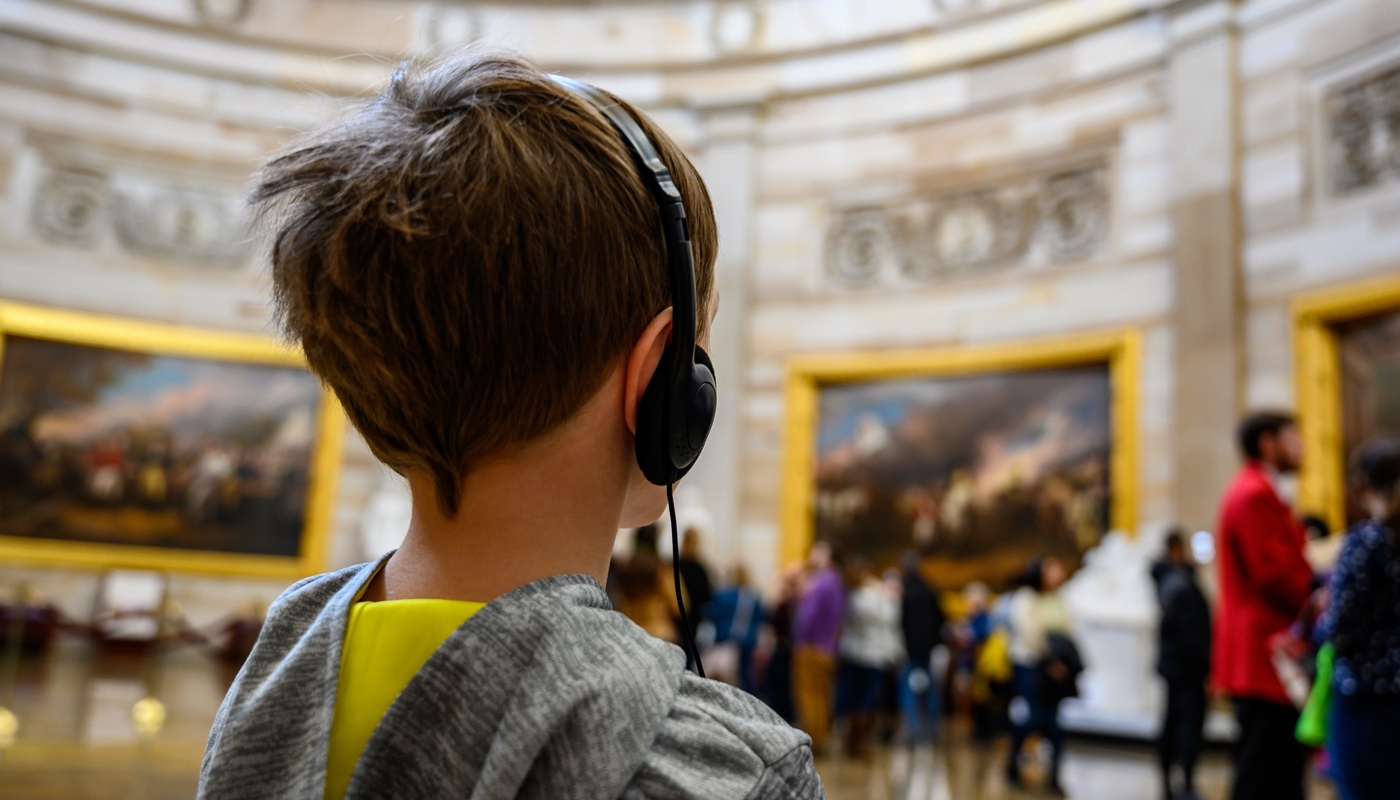 Young Caucasian boy with headset on tour of US Capital in Washington DC