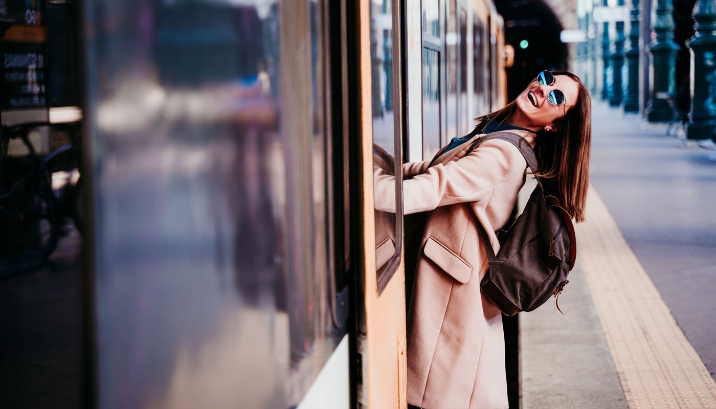 happy young woman at train station