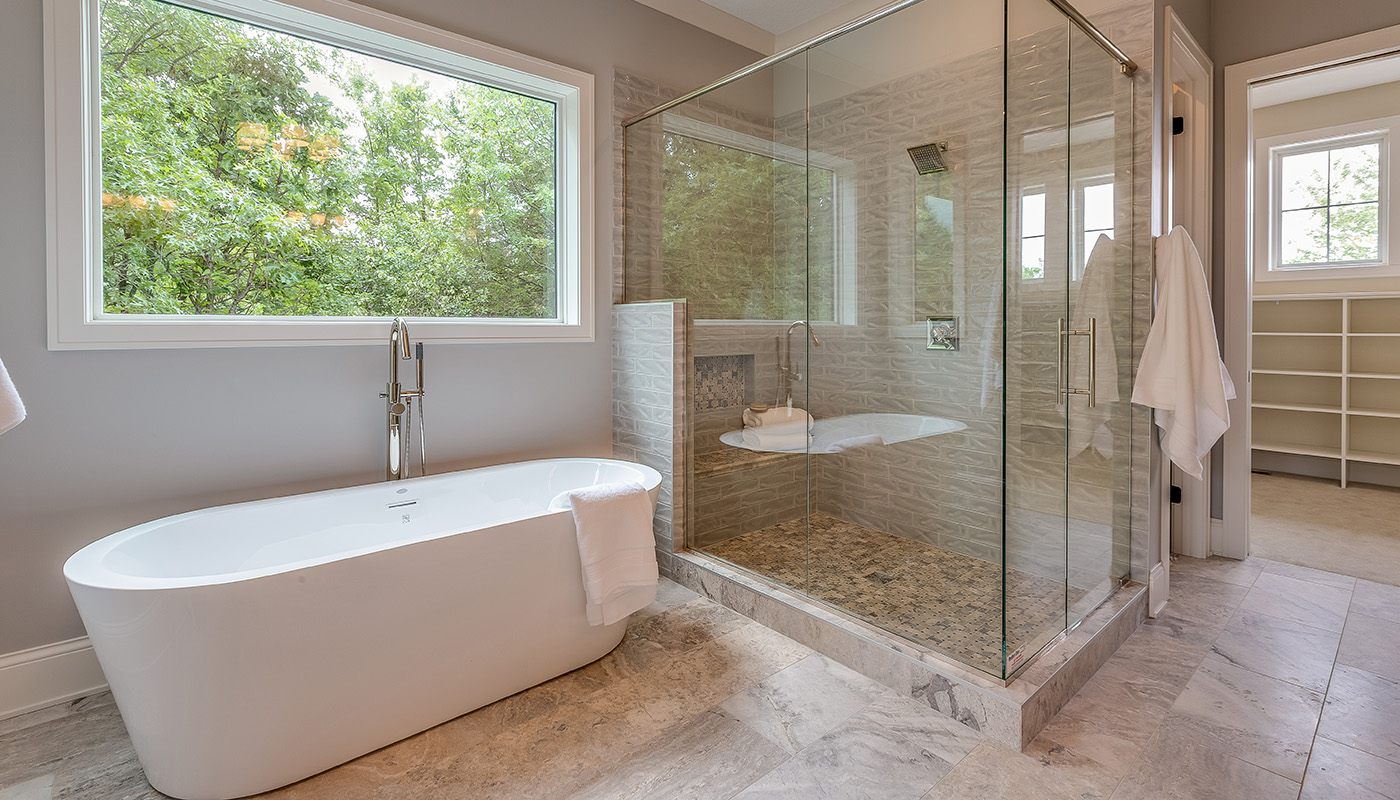 Renovated bathroom with freestanding bathtub and glass shower