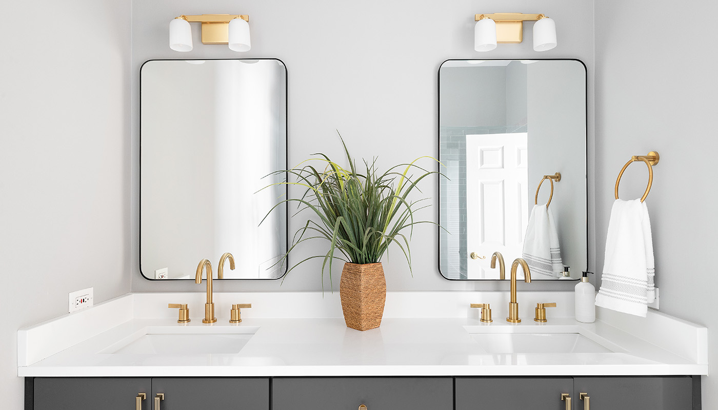 A bathroom vanity with two sinks and two mirrors hung above them.