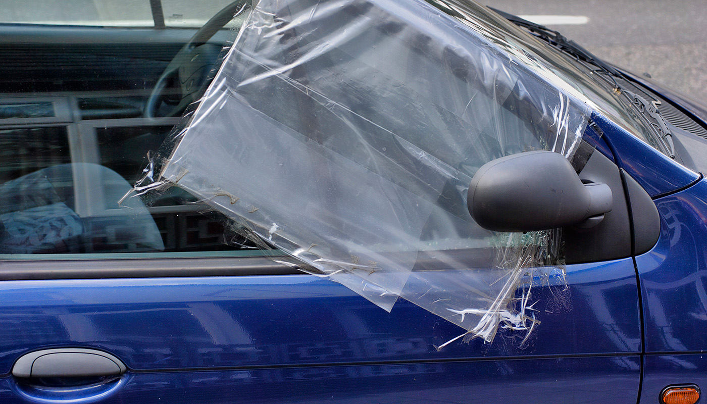 Plastic sheet taped over broken car window