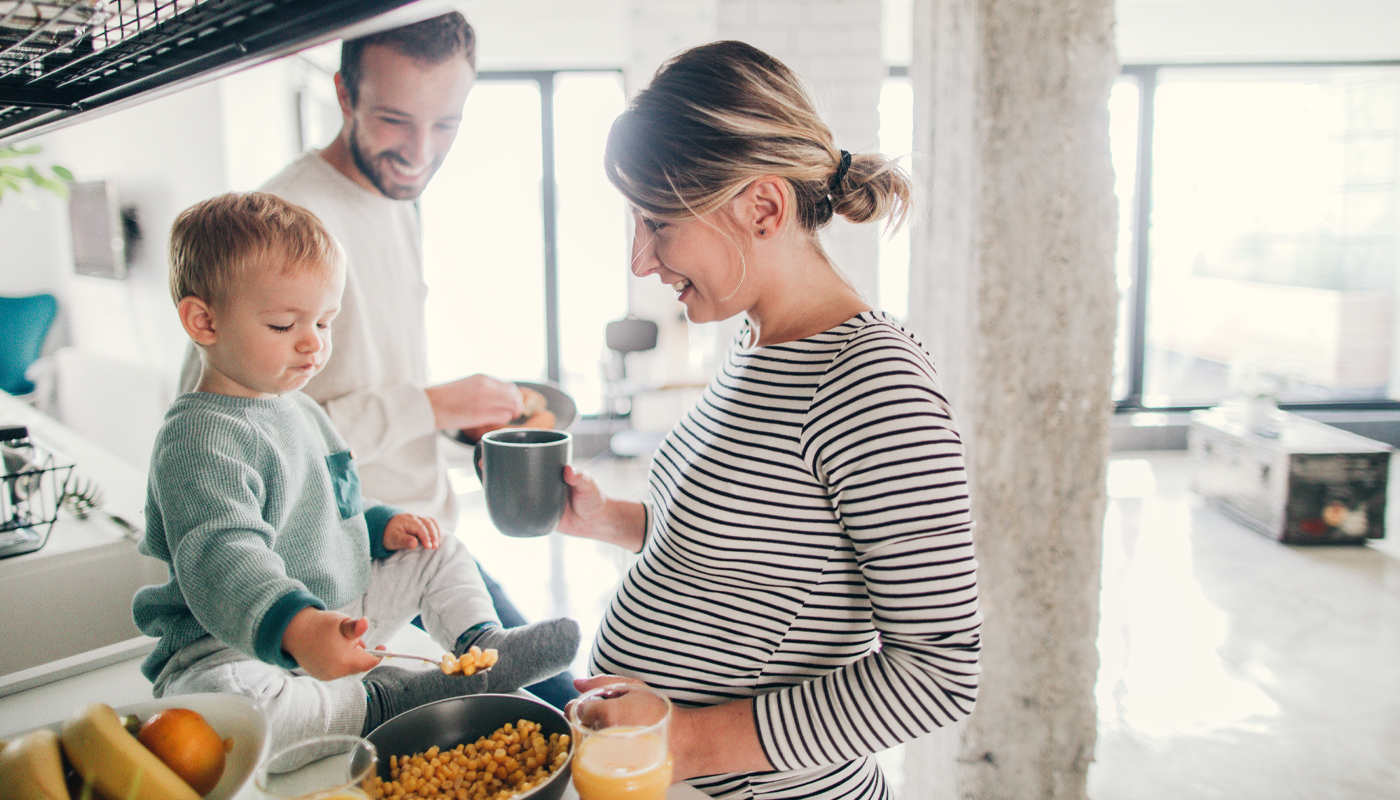 Young family preparing breakfast together in their kitchen