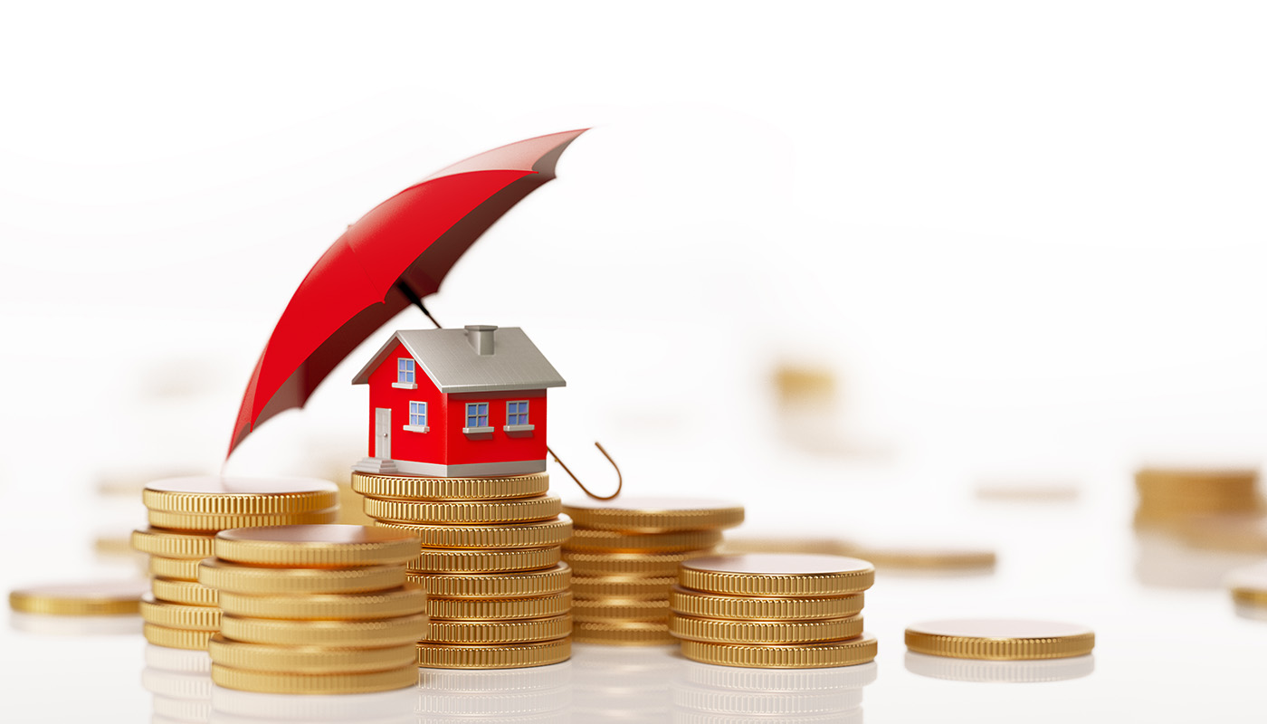 Miniature red house on stacks of gold coins, with miniature red umbrella propped up to shield it