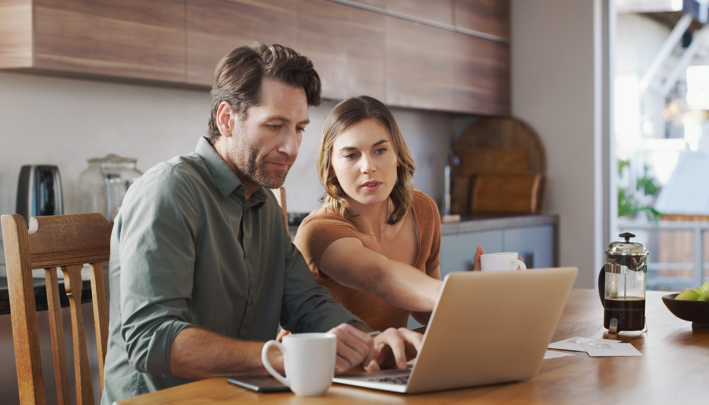Caucasian man and woman looking at laptop together