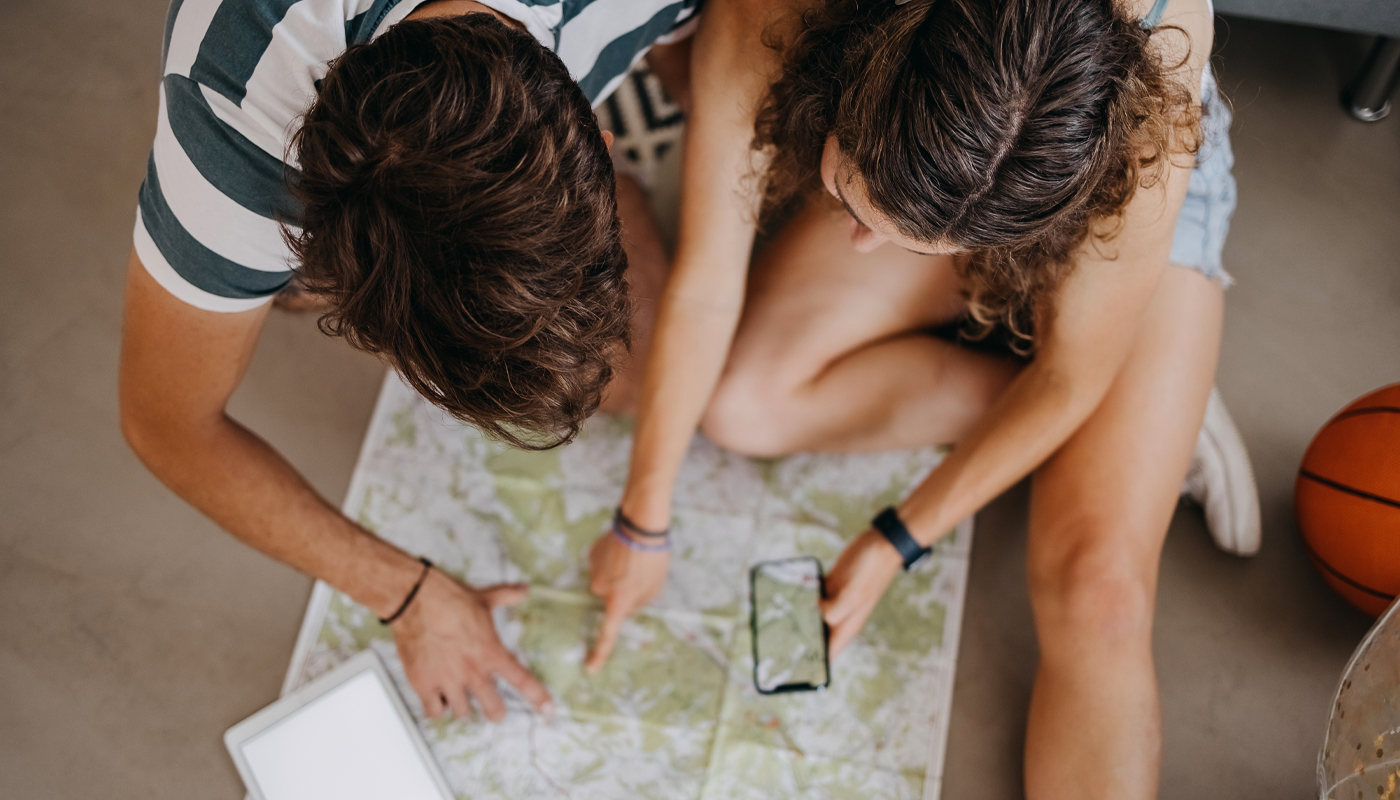 Young couple planning vacation trip using map
