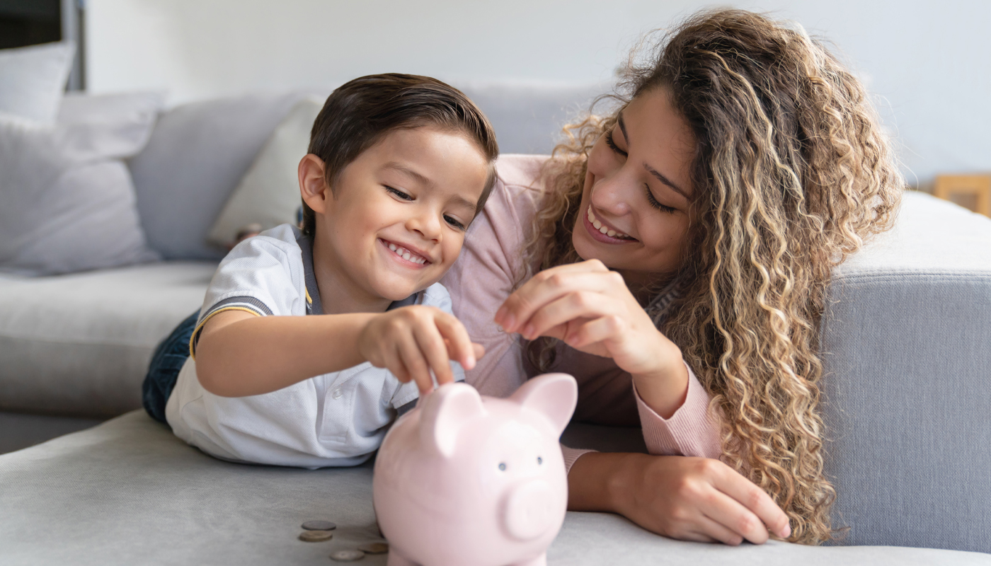 Mother and son saving money in a piggy bank