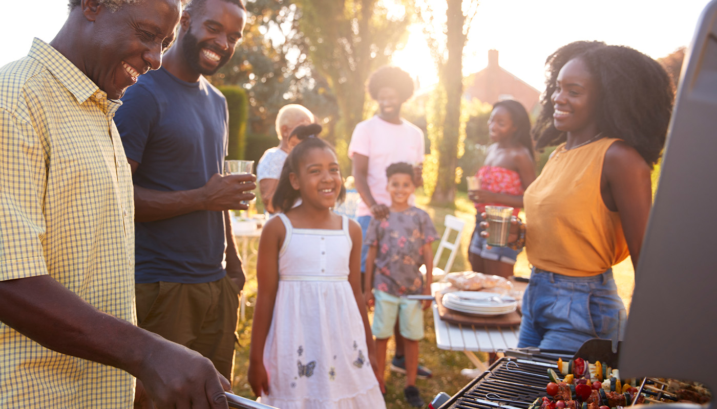 A family gathers outdoors for a barbecue.