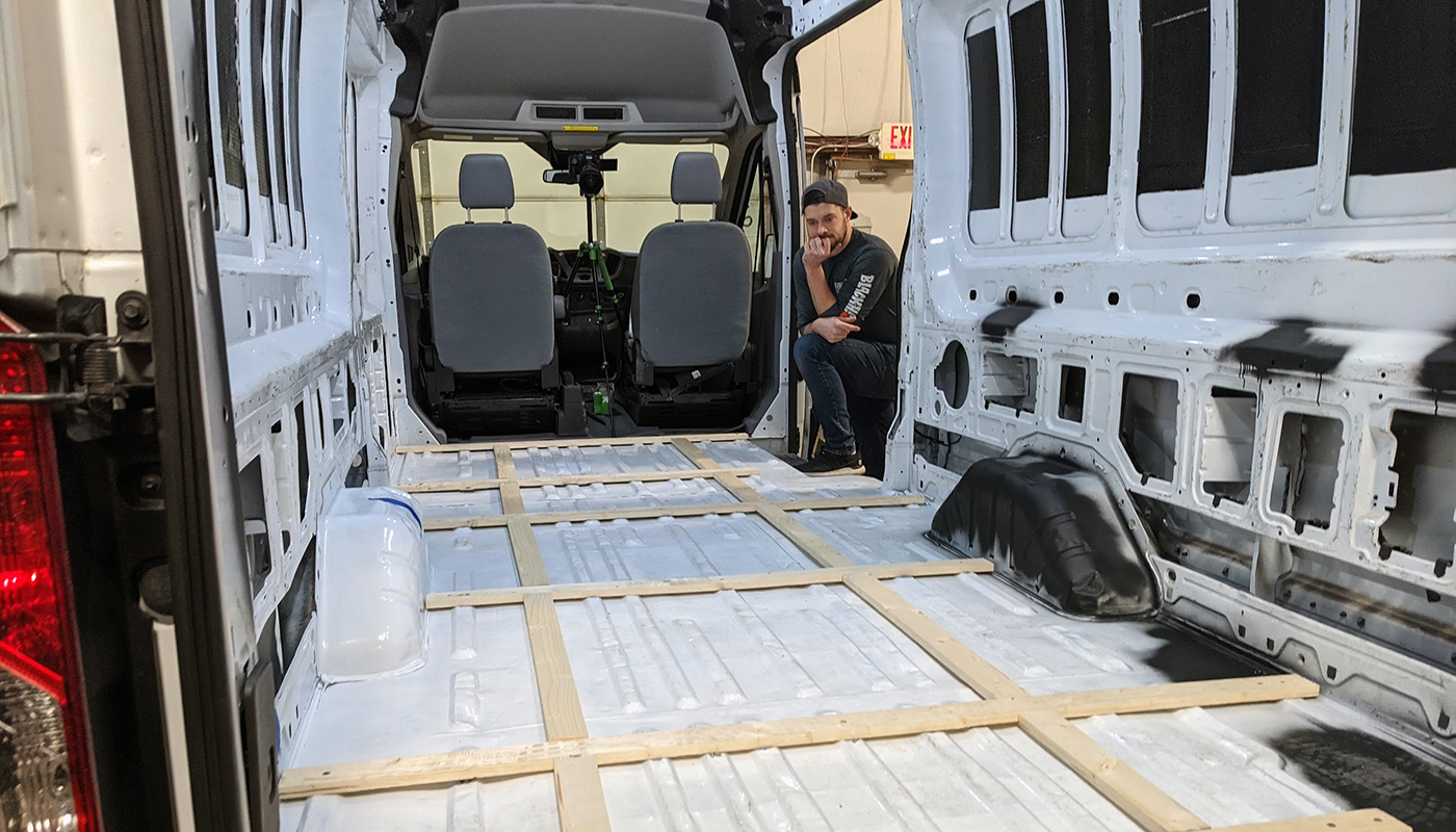 Inside an empty van with a wood frame floor.
