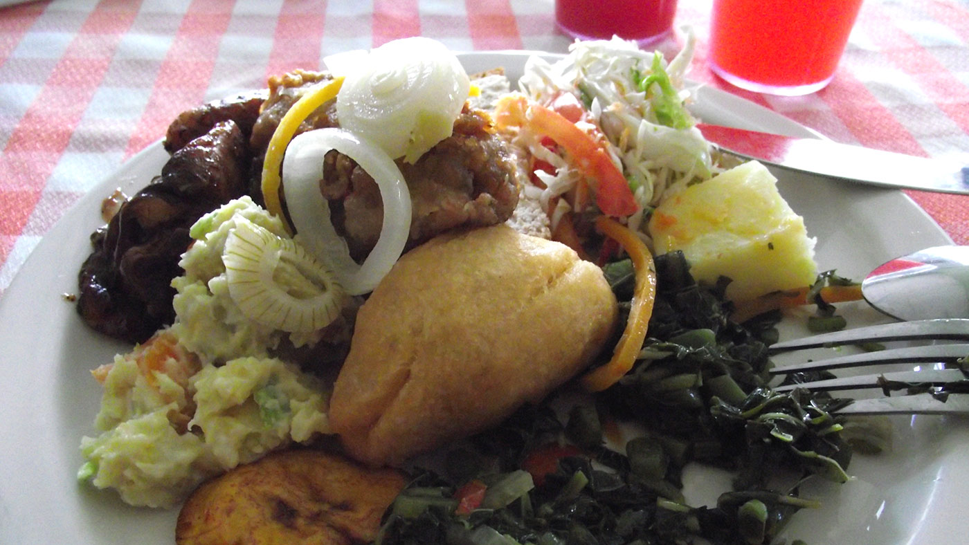 A traditional Jamaican meal including ackee, sweet bread, plantains and jerk chicken