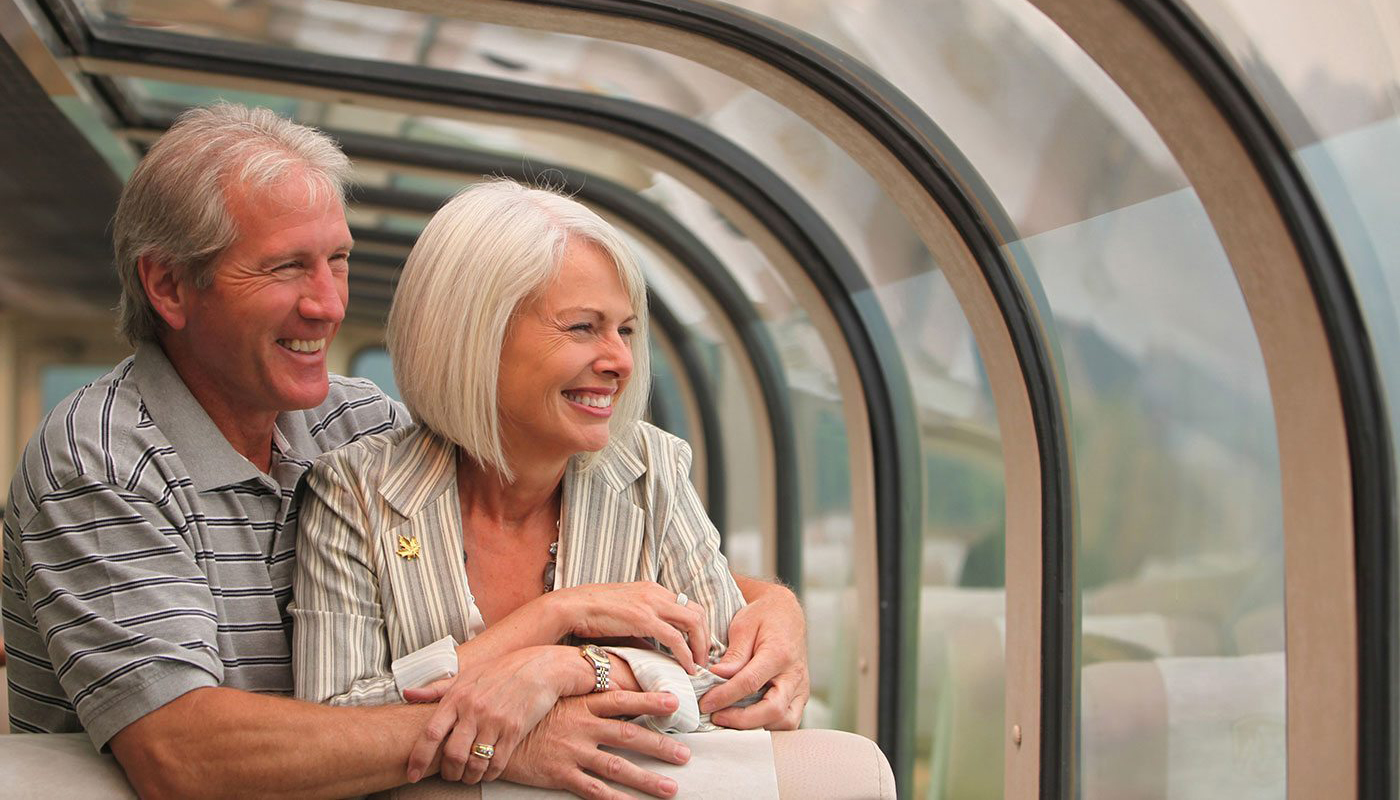 couple embracing each other while looking out a window on a train.
