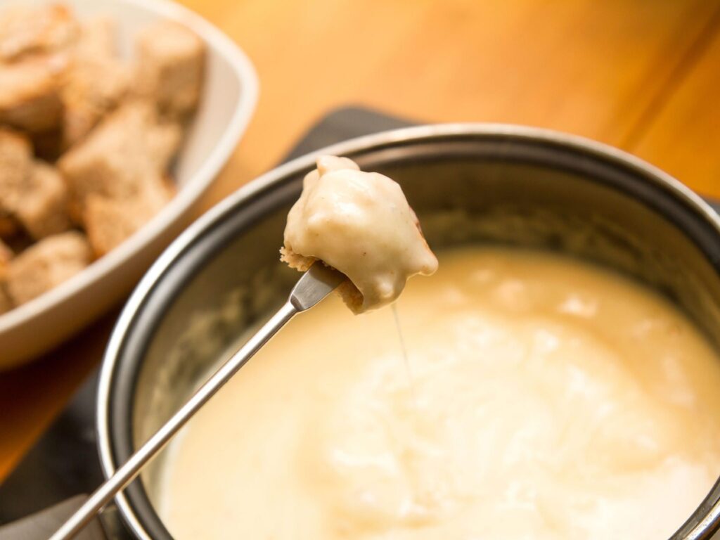 traditional recipe for a classic winter fondue melts Emmental and Gruyere cheese with white wine