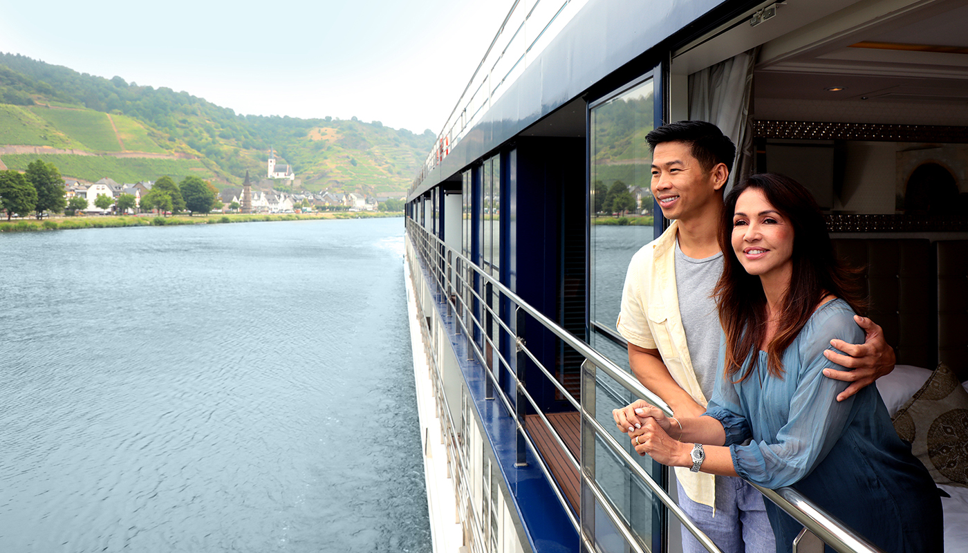 Couple on AmaWaterways river cruise standing in their cabin with twin balconies