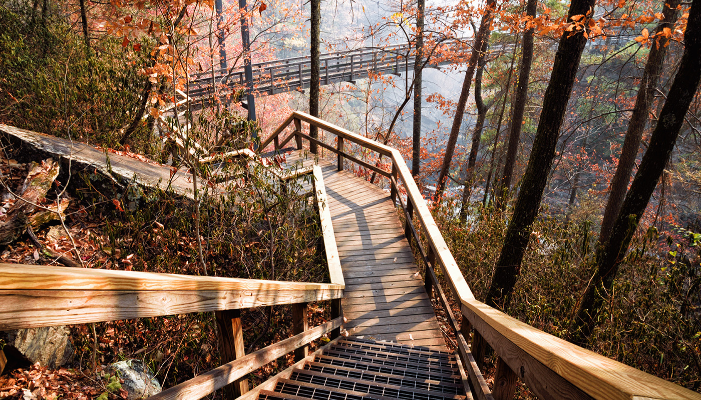 Wooden walkway leading towards a suspension bridge that crosses over the Tallulah River in Tallulah Gorge State Park