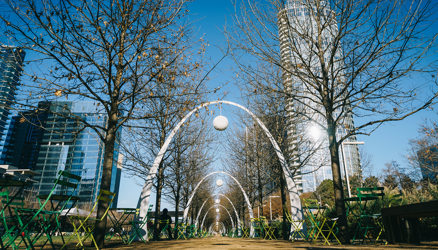 Trees, tables, chairs and arches in Klyde Warren Park during winter