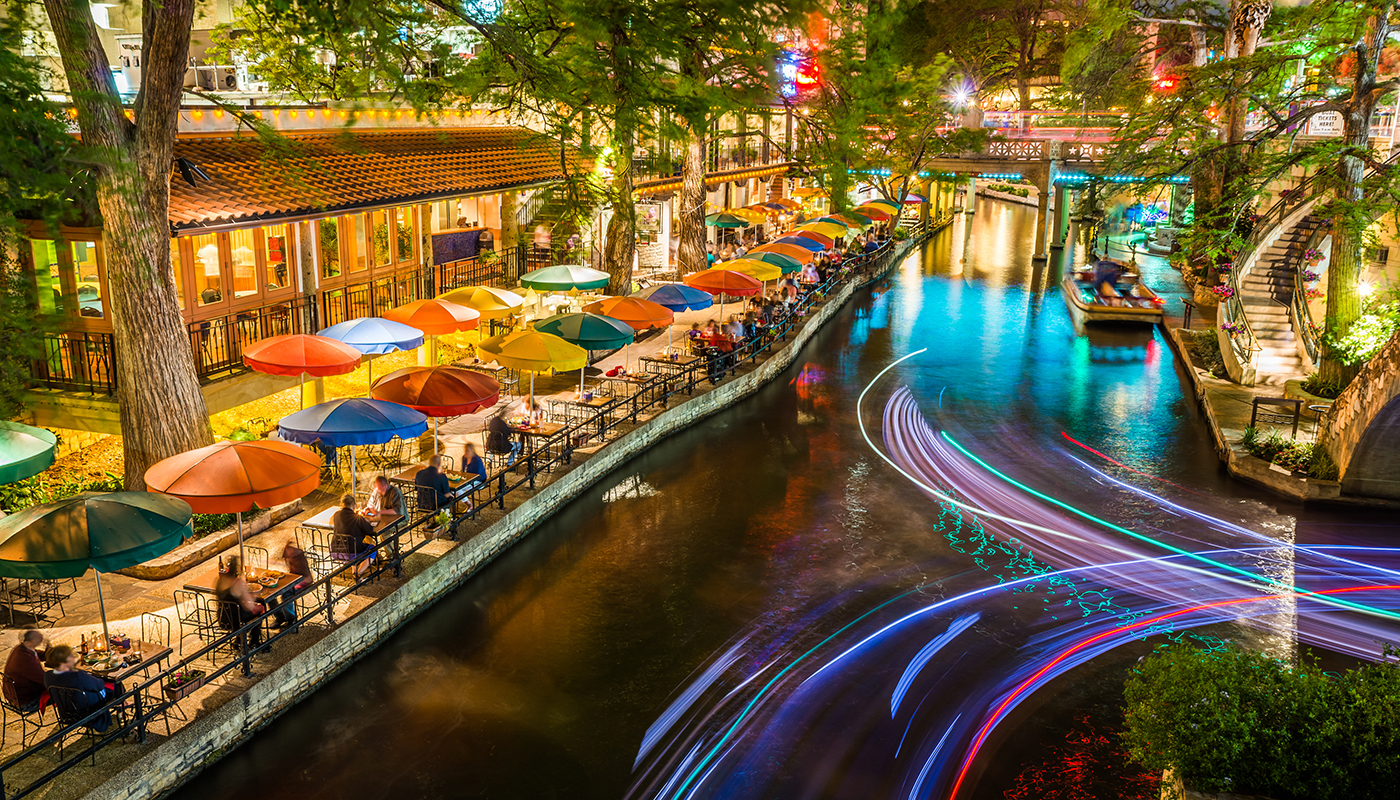 San Antonio Riverwalk - San Antonio Texas,  Famous tourism park walkway along scenic river canal at night. Light trails from tour boats.