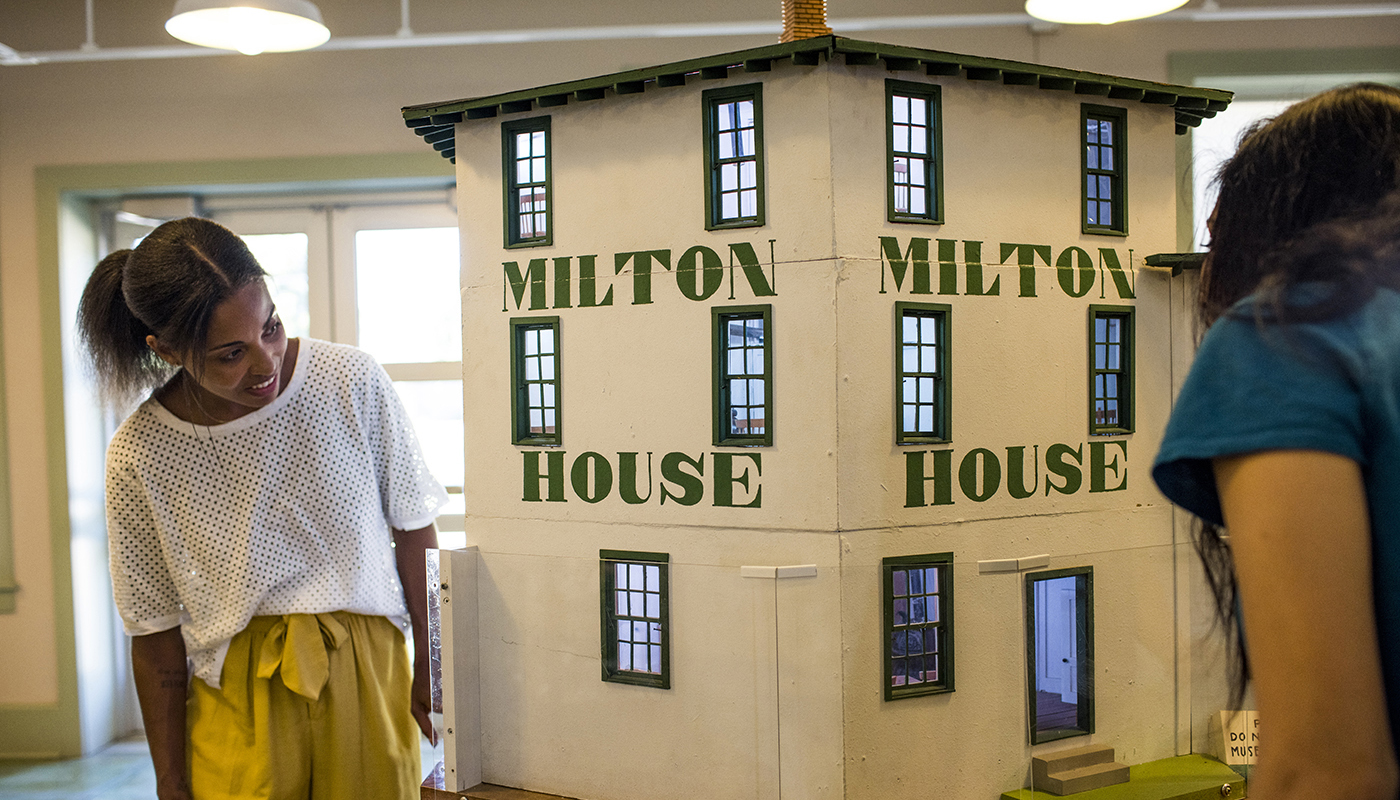 Visitors look at model of Milton House at Milton House Museum