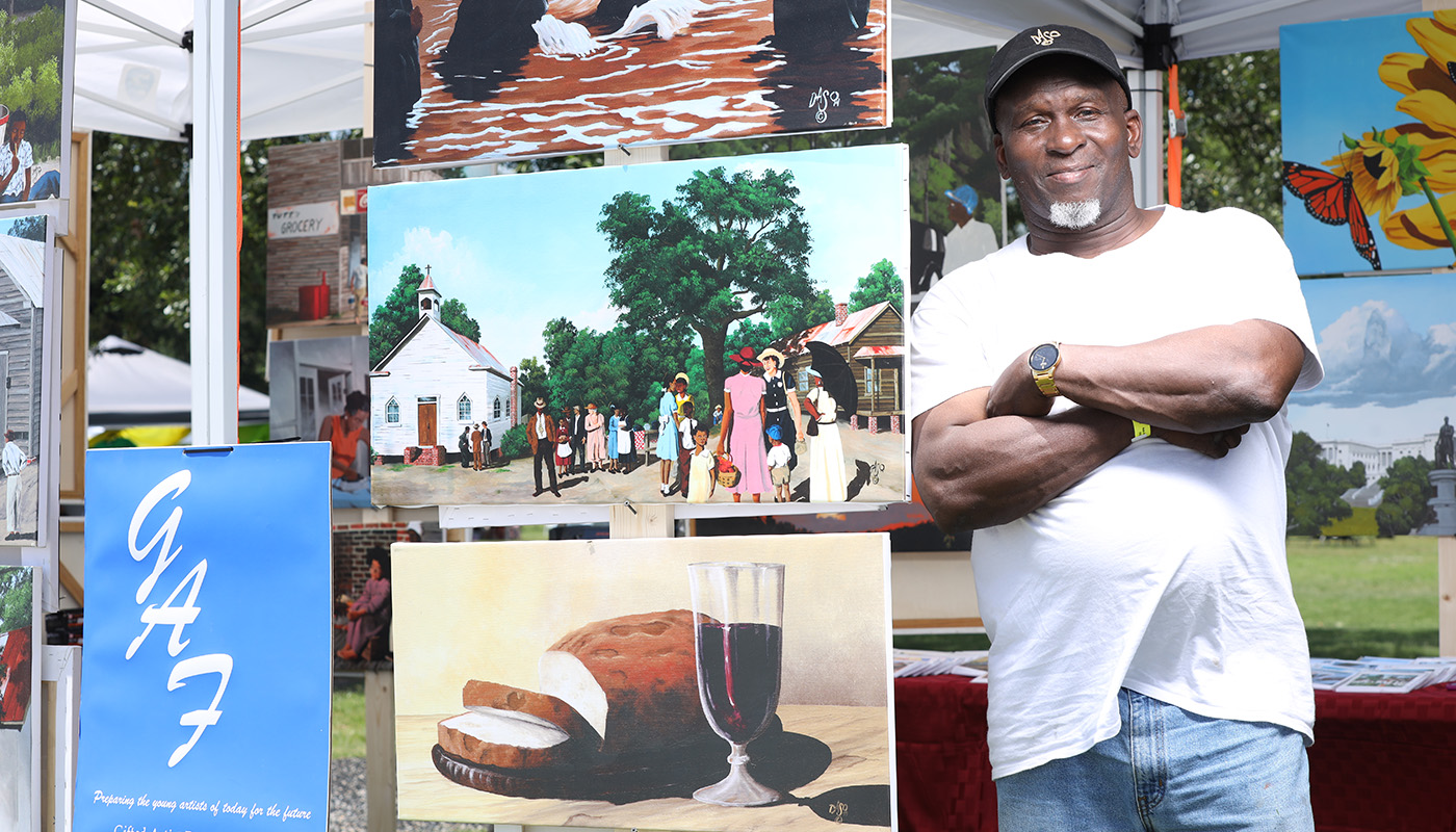 Man stands outside with pieces of artwork in Charleston, SC