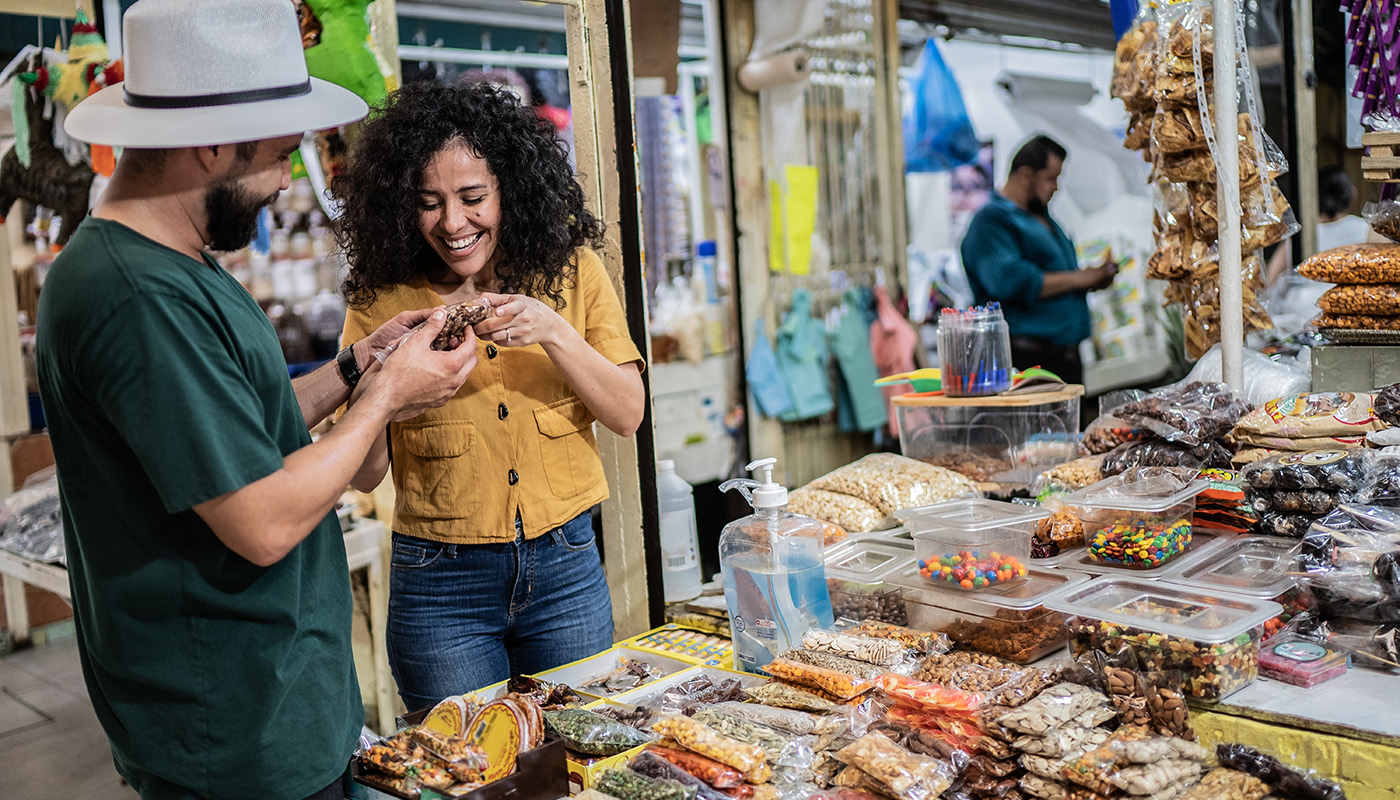 Young couple buying nuts and candy at a local food market