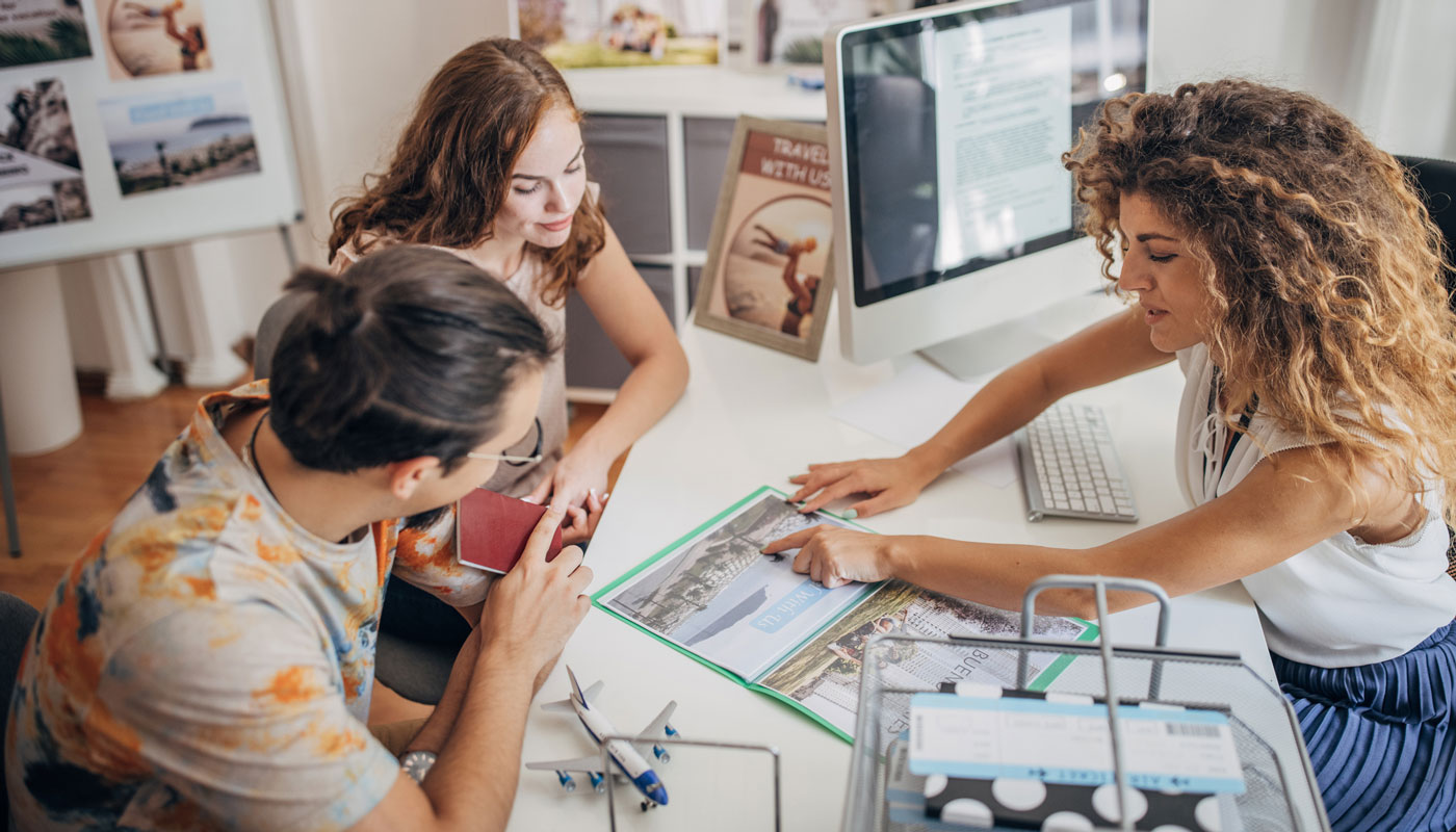 Travel agent working with a couple planning vacation.