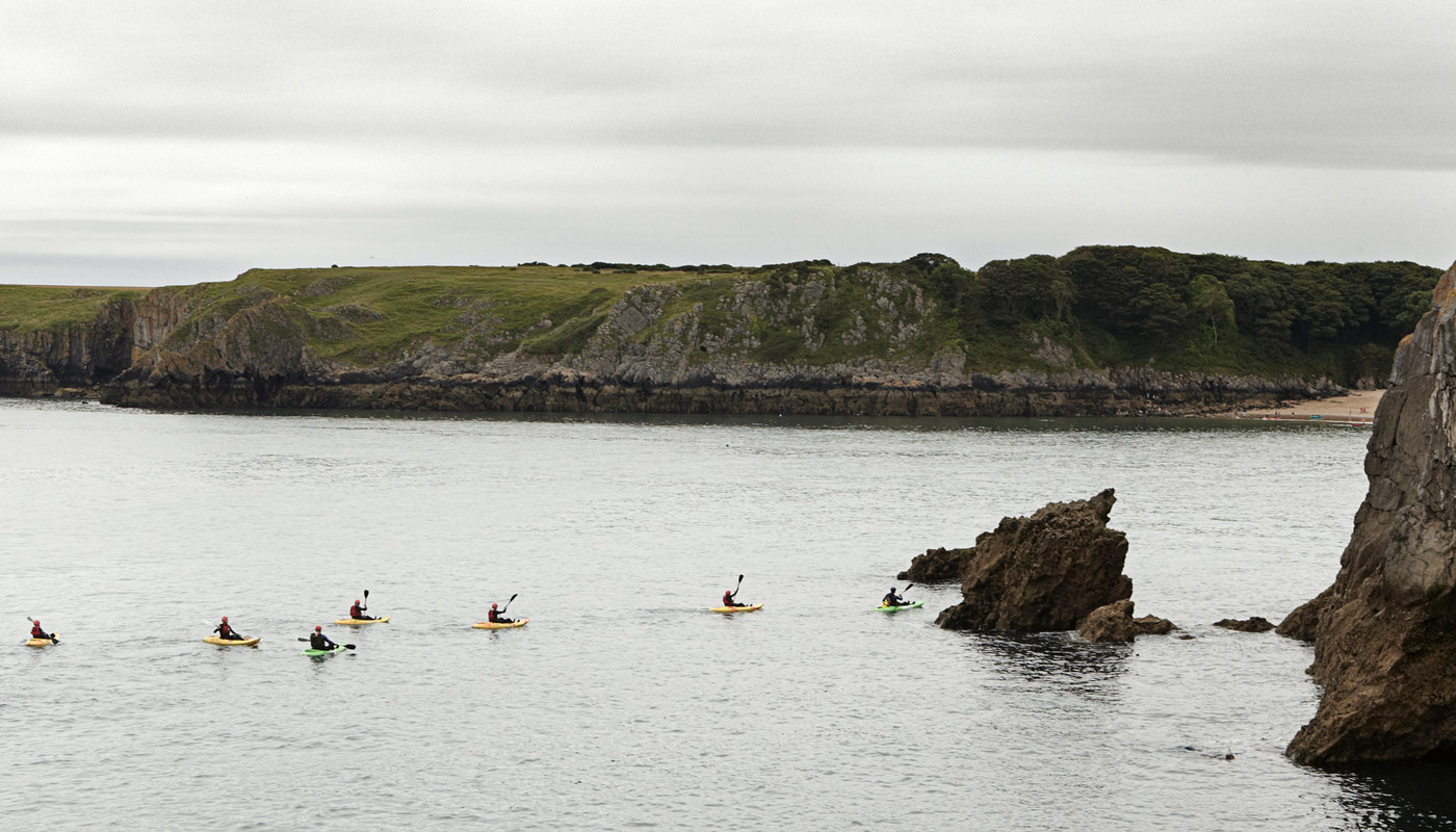 Sea and Welsh cliff faces with kayakers