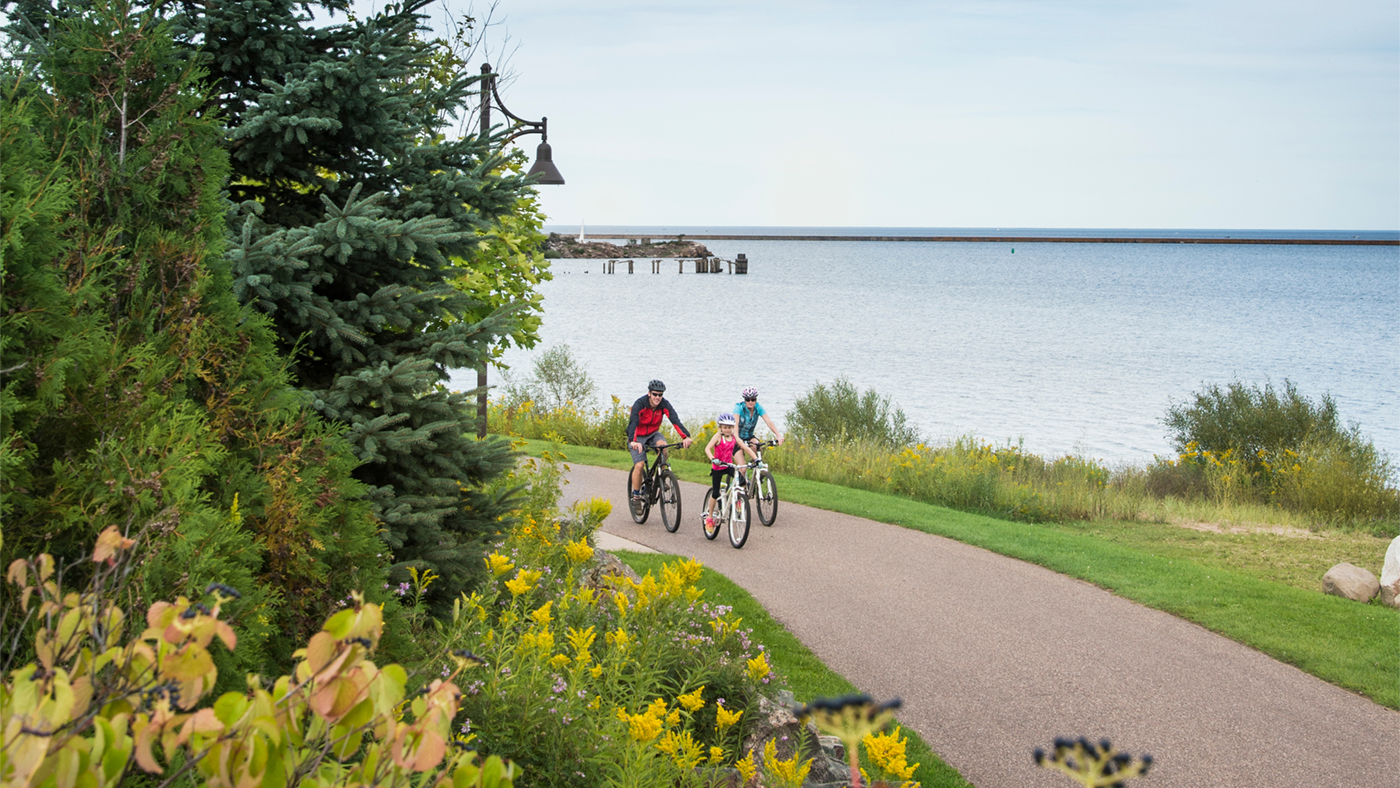 Family biking on the Iron Ore Heritage Trail along Lake Superior in Marquette, Michigan