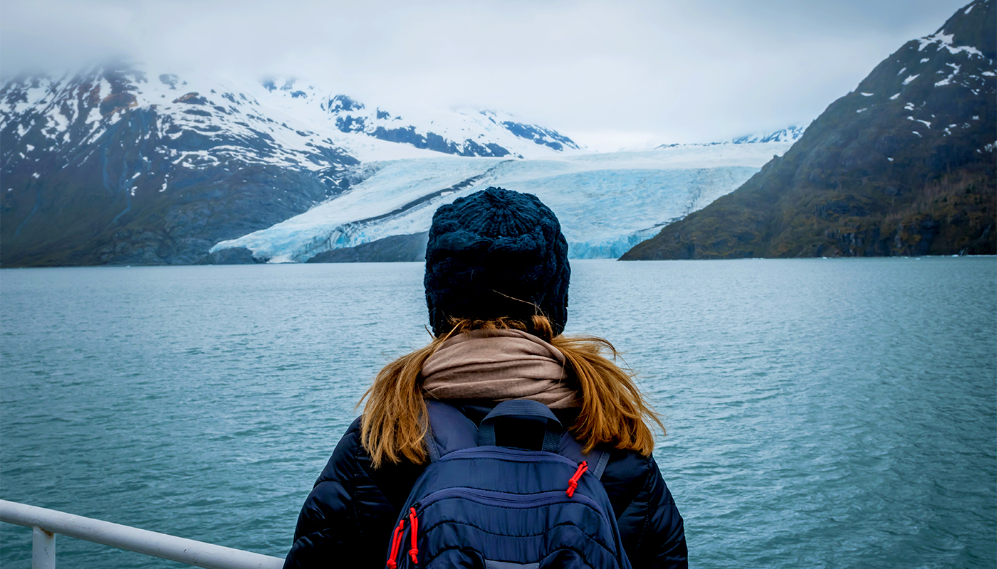 Woman on a cruise ship looking at the Portage glacier in Alaska