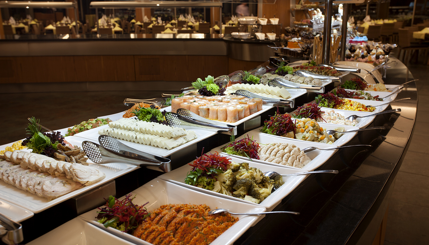 Buffet of food dishes displayed on long table in a restaurant