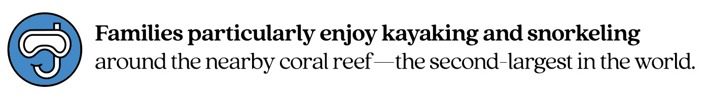 Pull quote stating “Families particularly enjoy kayaking and snorkeling around the nearby coral reef—the second-largest in the world.”