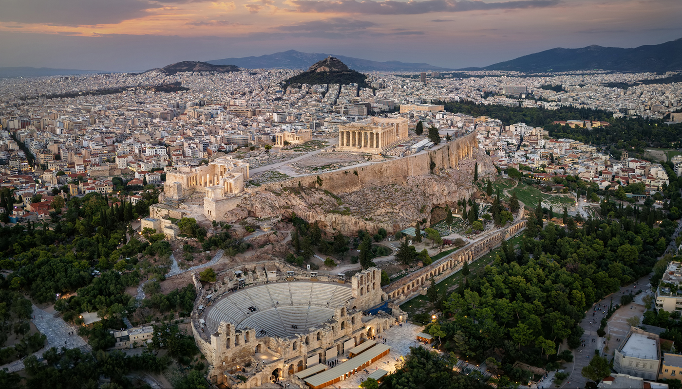 Panoramic aerial view of the Parthenon Temple and the Odeon of Herodes Atticus Theatre at the Acropolis of Athens, Greece, during sunset time