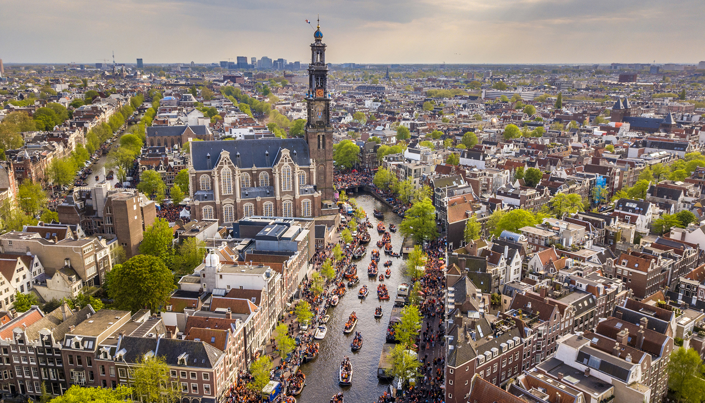 Amsterdam aerial view of Westerkerk church seen from north on Koningsdag Kings day festivities. Birthday of the king. Seen from helicopter.