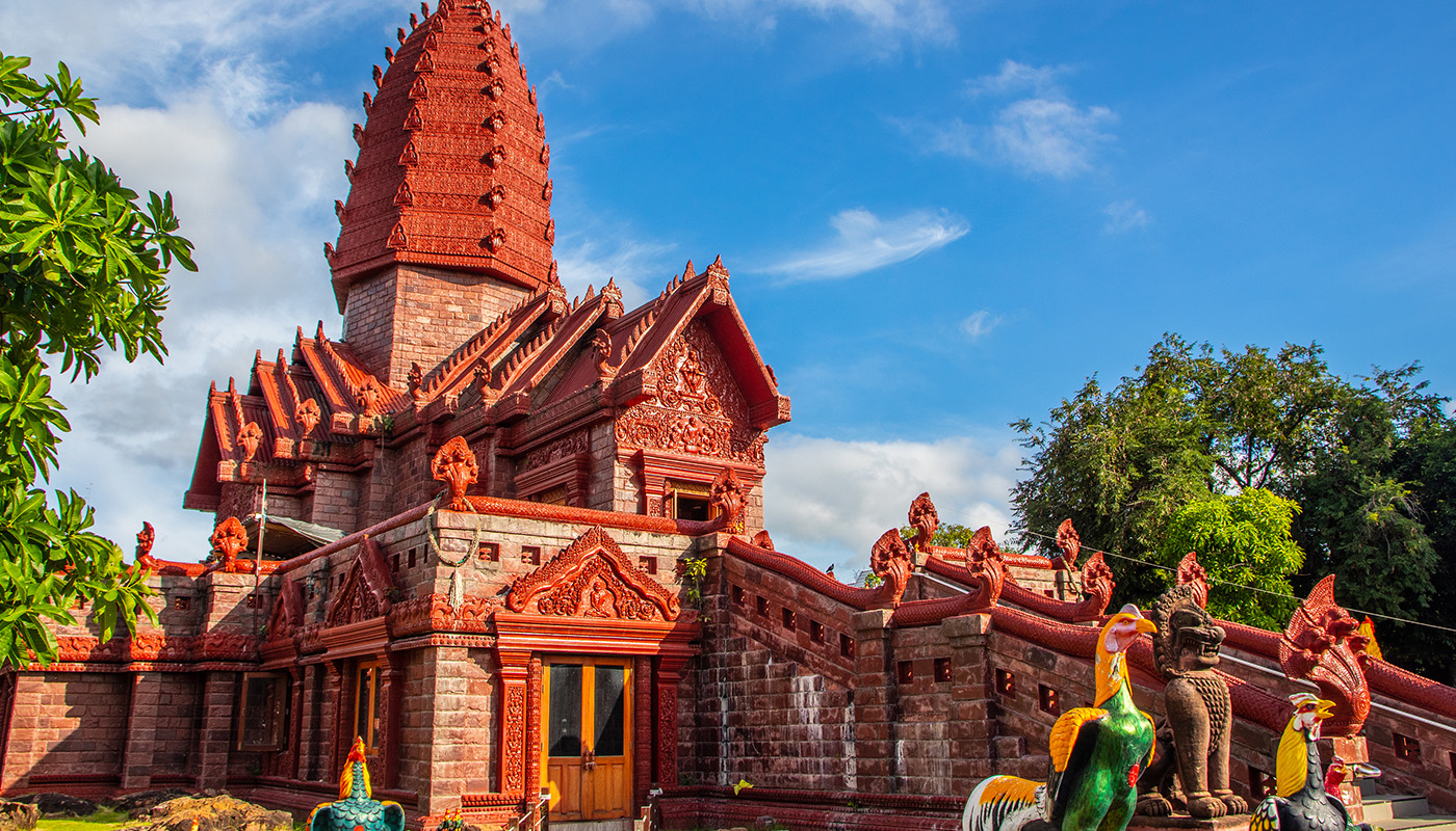 An intricately detailed building nestled among the trees in Thailand. 