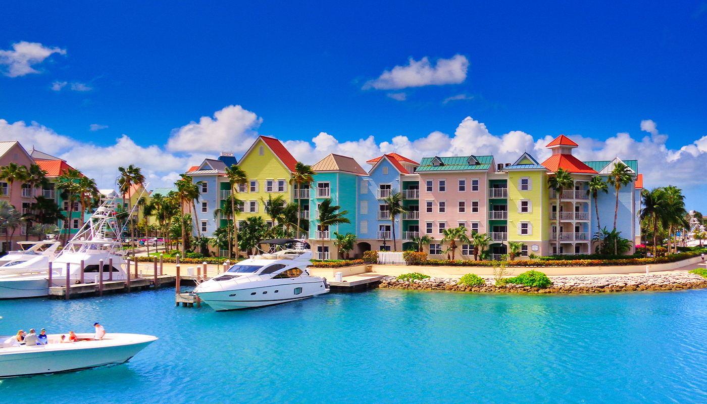 Boats drift leisurely on the water with colorful condo complexes in the background. 