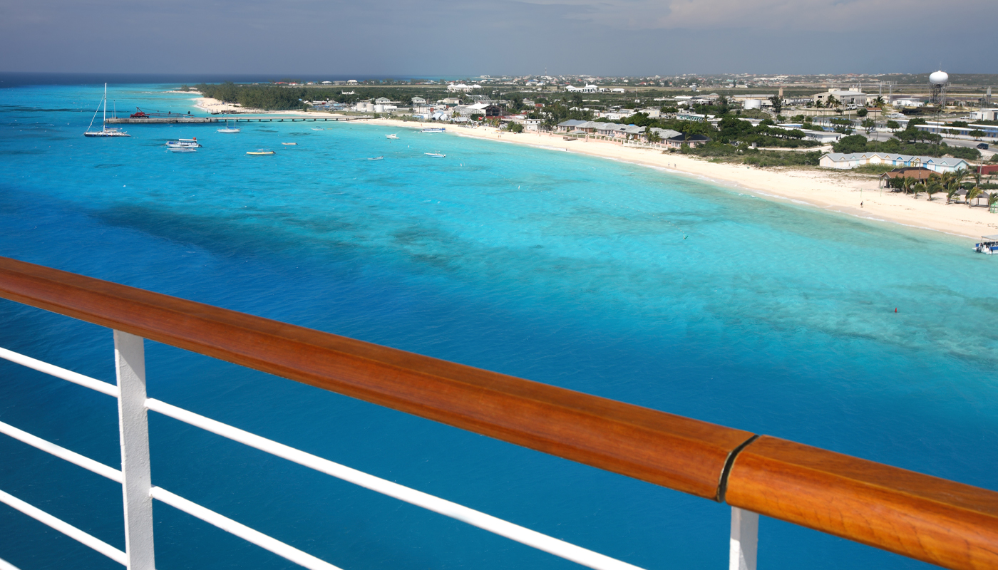 A view of a beach from the rail of a cruise ship. 